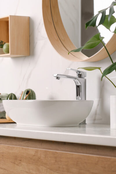 Stylish vessel sink on light countertop in modern bathroom