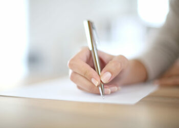 Closeup of woman's hand writing on paper