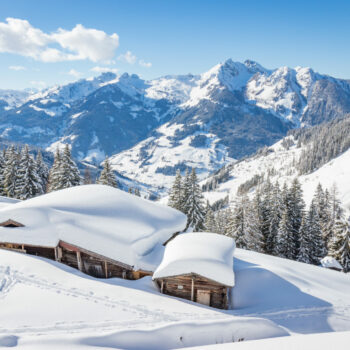 Beautiful winter mountain landscape with snowcapped wooden hut